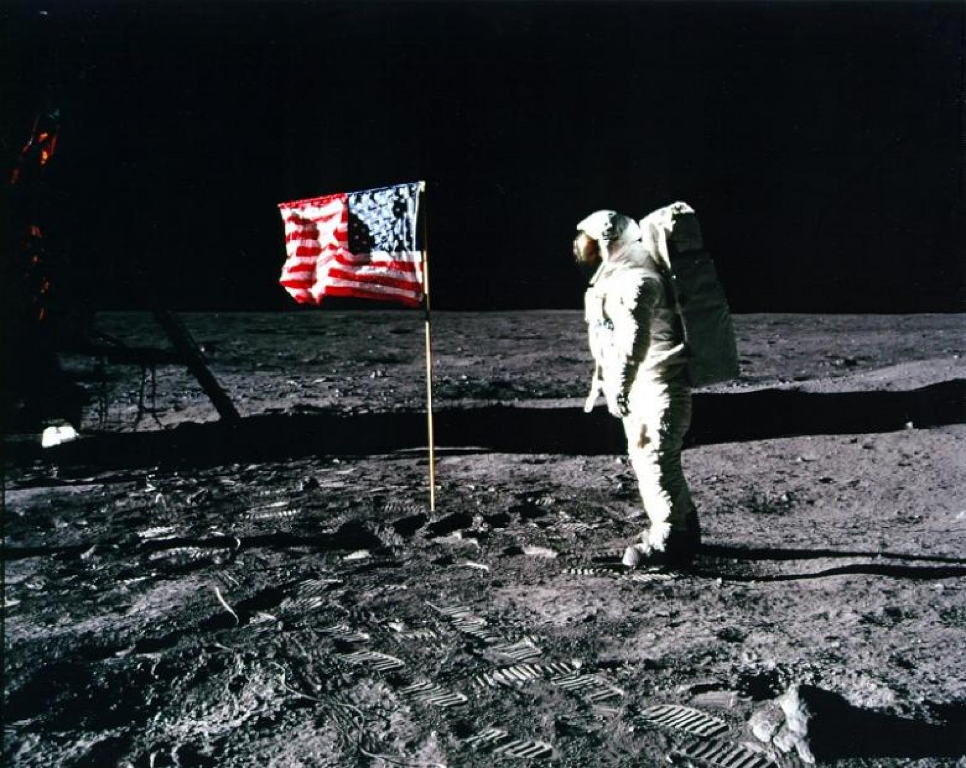 Astronaut walks on the moon with a USA flag in the background