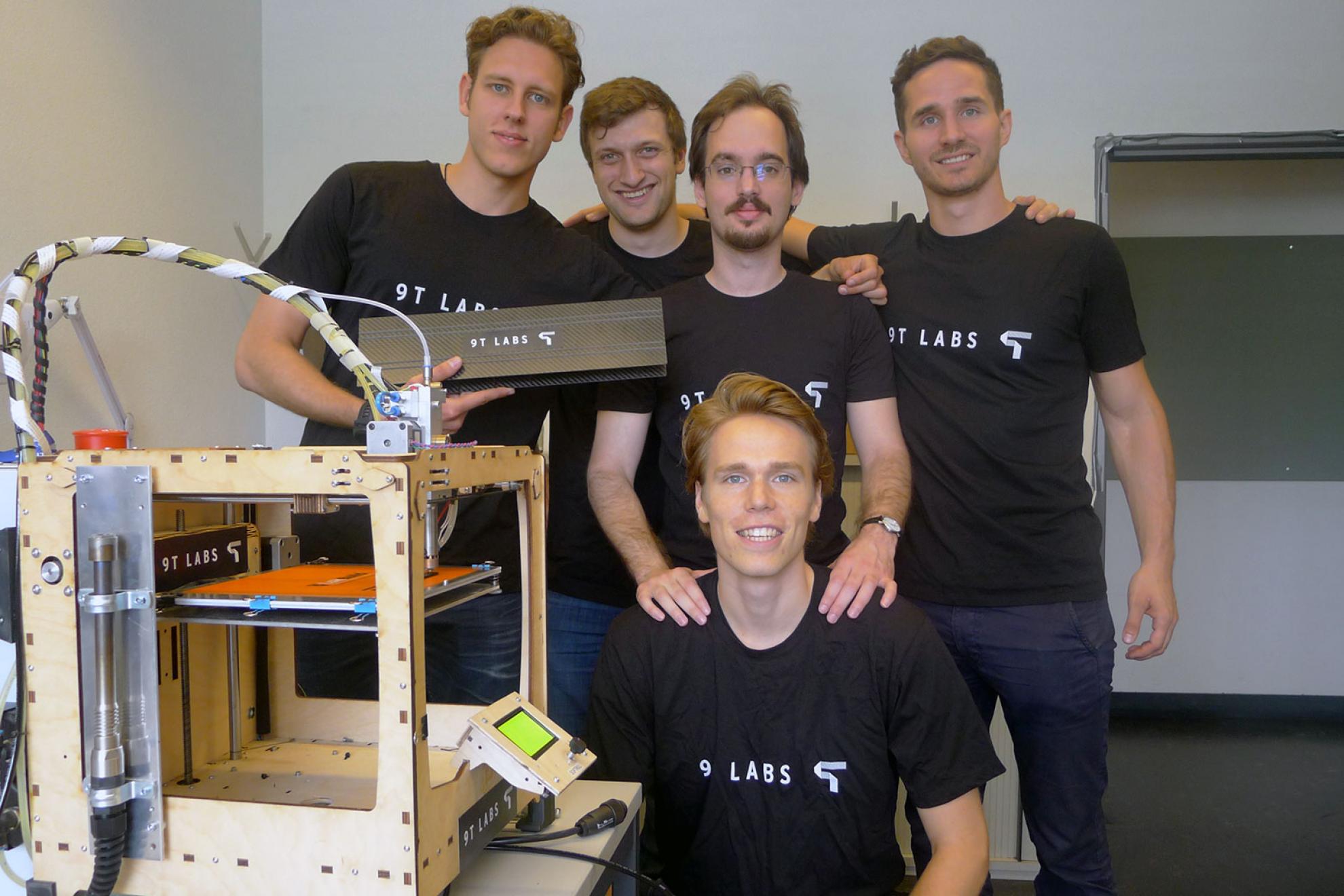 Part of 9T Labs team next to the prototype 3D printer during their time at ETH Zurich